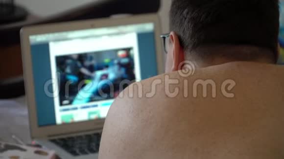 男人在家里用笔记本电脑看在线电影视频的预览图