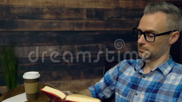 穿格子衣服的人读一本书视频的预览图