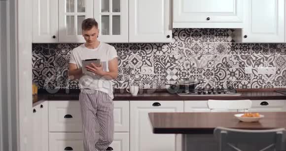 在厨房里使用小器具的站立夫妇视频的预览图