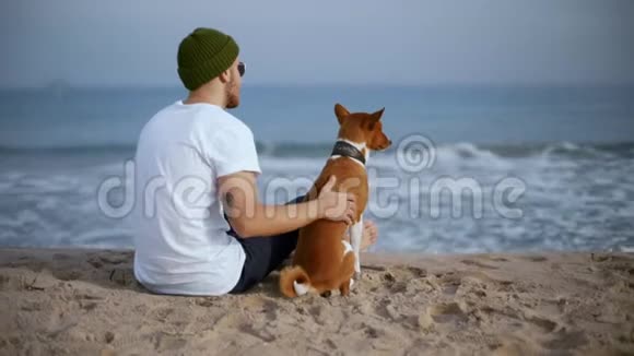 年轻的千禧一代和最好的朋友狗在海滩视频的预览图