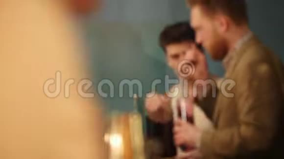 年轻的职业酒保闻着一杯红饮料和酒吧后面的另一个酒保说话视频的预览图
