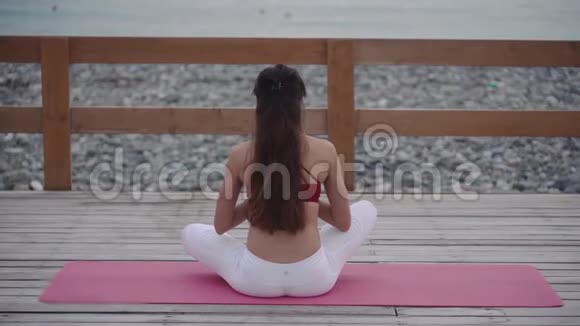 女人坐在莲花的位置沉思着看着海景看着背影视频的预览图