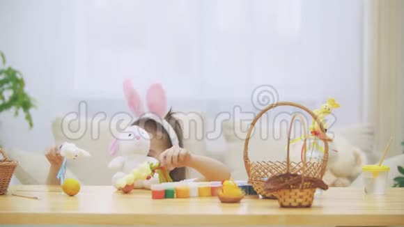 小可爱可爱的女孩正笑着玩着五颜六色的鸡肉鸡蛋和兔子概念复活节假期视频的预览图
