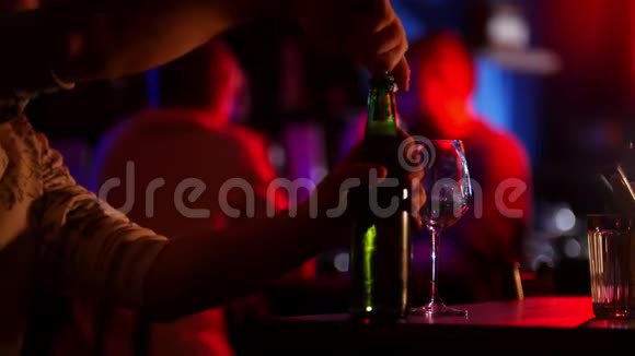带霓虹灯的酒吧一个人打开一瓶啤酒倒在玻璃杯里视频的预览图