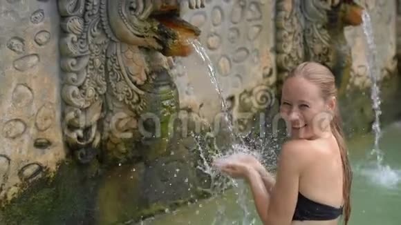 年轻女性游客参观巴厘岛著名的班贾尔温泉巴厘旅行概念视频的预览图