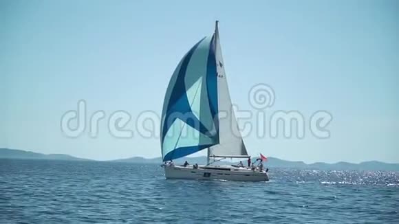 带条纹帆的游艇冲进蓝色的深海慢动作表演地中海海滨视频的预览图