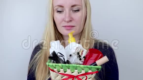 男人给漂亮的女孩一份礼物一个篮子里面有化妆品和卫生用品生日的惊喜情人节的视频的预览图