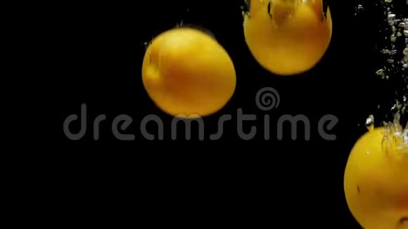 桃子和杏落在透明的水中的黑色背景视频的预览图