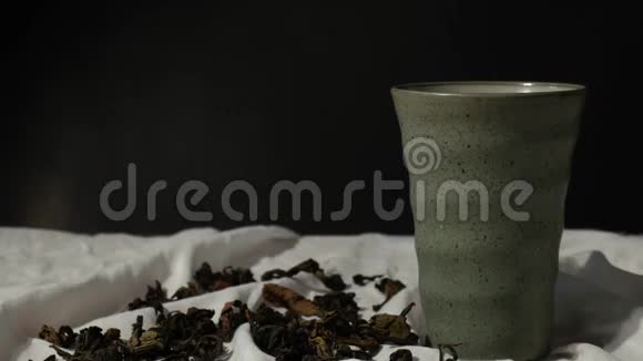 将热红茶倒入杯中在白色背景上加入干茶叶视频的预览图