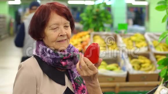在超市里特写一位老妇人拿着红辣椒视频的预览图