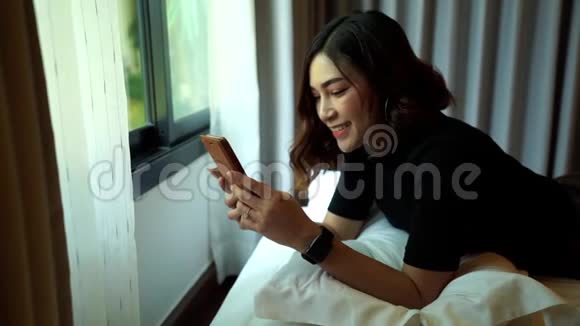 女性在床上使用智能手机的动作缓慢视频的预览图