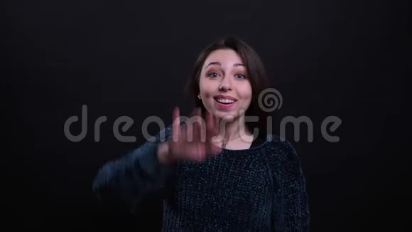 一幅成年白种人的特写肖像美丽的白种人深褐色头发的女性用手打招呼看着背景镜头视频的预览图