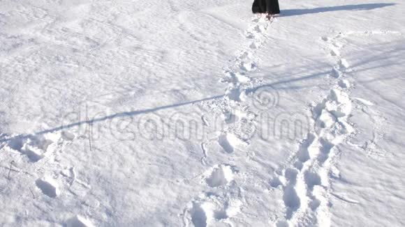 一个穿着黑色外套的女孩走在雪地里痕迹消失了视频的预览图