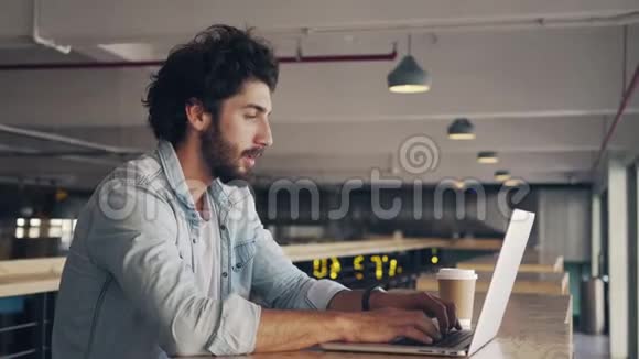疲惫的商人在自助餐厅使用笔记本电脑视频的预览图
