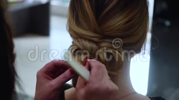用发夹固定头发上的头发理发师做一个时髦的有长发的新娘发型视频的预览图