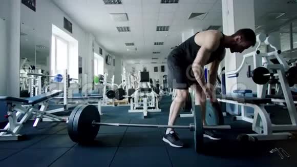 年轻的运动员在健身房锻炼前要把体重放在杠铃酒吧视频的预览图