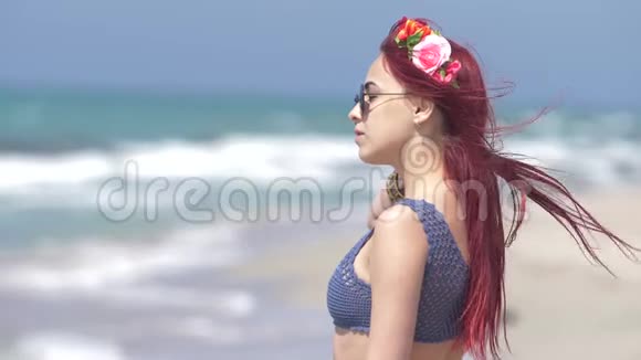 风中飞舞的红发少女在大海的背景下她的头发上戴着花圈视频的预览图