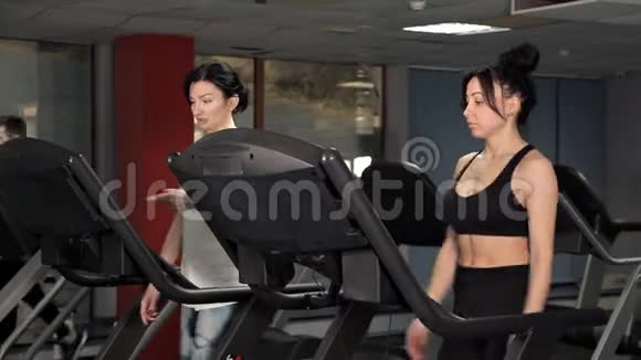 年轻女性适合在跑步机上健身房做跑步锻炼视频的预览图