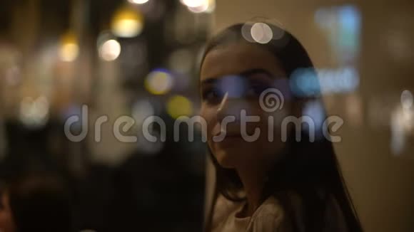 迷人的年轻女士在咖啡馆里享受时光坐在窗边微笑视频的预览图