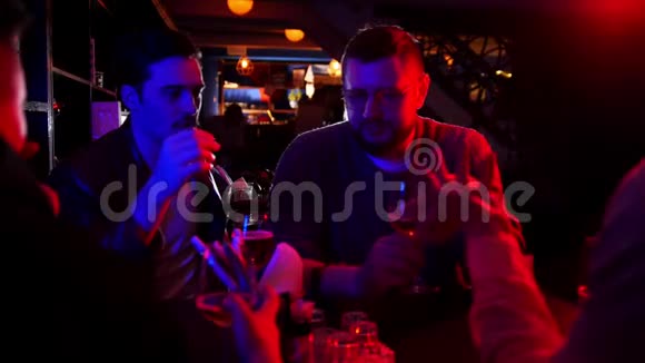 带霓虹灯的酒吧朋友们一起聊天一起喝玻璃啤酒视频的预览图
