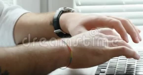 一个人在他的笔记本电脑上打字看着窗外视频的预览图
