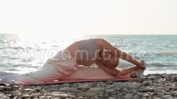 运动女性在海边伸展腿部肌肉视频的预览图