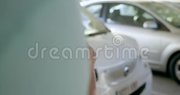 男人打开租赁电动共享汽车电话视频的预览图