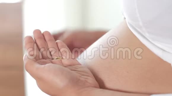 怀孕的拉丁美洲女人手里拿着粉红色的药丸视频的预览图