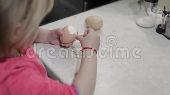 一个小女孩用一个煮熟的鸡蛋清理外壳视频的预览图