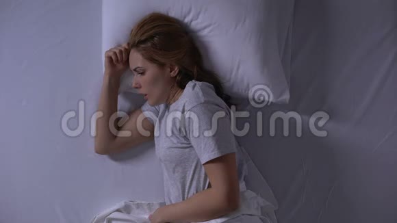 迷人的女人晚上躺在床上哭泣女人的虚弱和脆弱视频的预览图