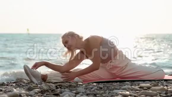 运动女性在海边伸展腿部肌肉视频的预览图