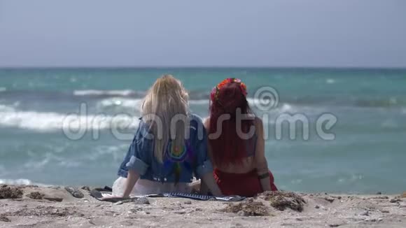 两名穿着波霍风格的年轻女子的后景在海滩上休息视频的预览图