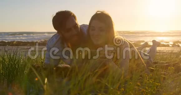 浪漫的情侣在海滩上玩手机视频的预览图