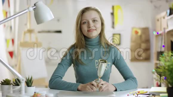 年轻女子向镜头展示冠军杯视频的预览图