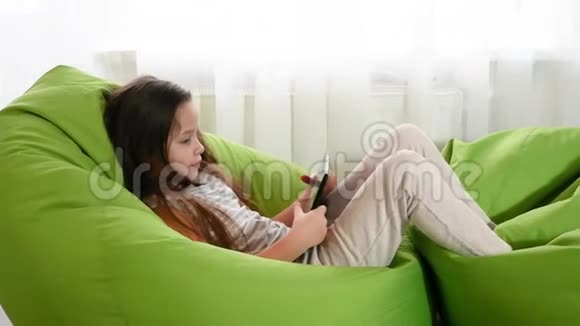 小女孩坐在椅子上用笔记本电脑快乐的乐趣关闭技术玩家慢动作胜利者欢乐的情绪视频的预览图