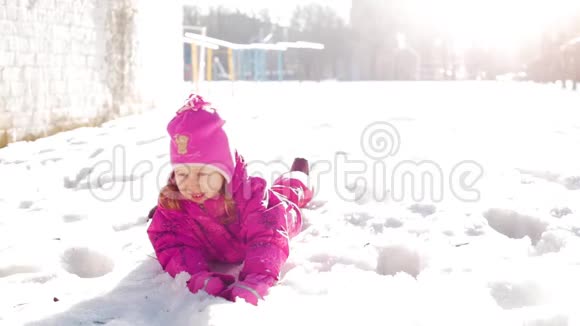 小女孩在雪地里玩耍孩子们在阳光明媚的冬日里尽情玩耍视频的预览图