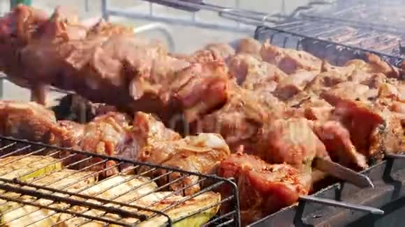 街头美食准备烤串和西葫芦工人在烤架上煮肉和蔬菜视频的预览图