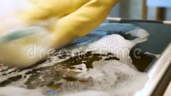 用洗涤剂用海绵清洗电炉的滚刀平板滚刀清洗关门视频的预览图