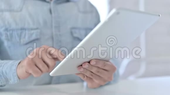 把年轻人的手在平板电脑上打字视频的预览图