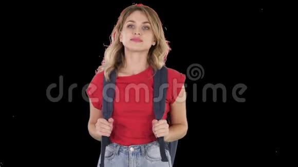 年轻漂亮的女士穿着休闲T恤背包和牛仔裤行走阿尔法频道视频的预览图