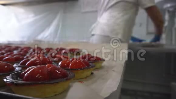 有馅的糕点工人把蛋糕折叠成包装带水果和浆果的篮子蛋糕面包制品视频的预览图