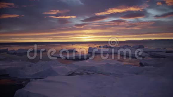 北极景观与冰山在格陵兰冰峡湾与午夜太阳日落日出在地平线上空中无人机视频的预览图