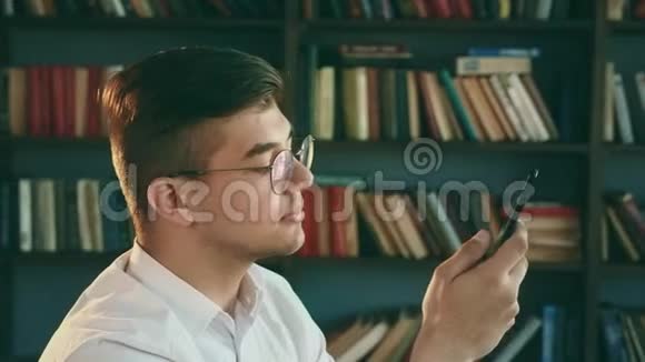 图书馆里的那个人正在看手机学生使用手机视频的预览图