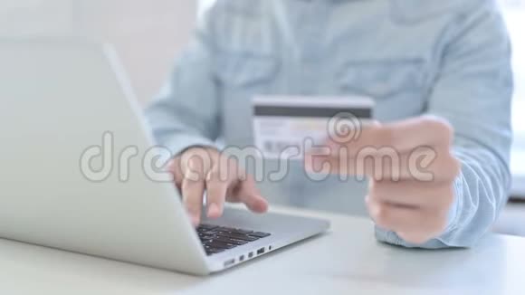 在手提电脑上使用信用卡将青少年手举起来视频的预览图