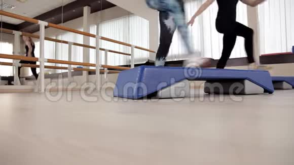 阶梯平台脚踩在台阶平台上健身房里的课健身健美操视频的预览图