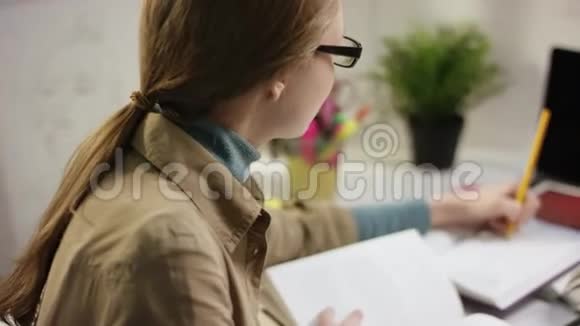 使用学习书籍在家学习的女学生视频的预览图