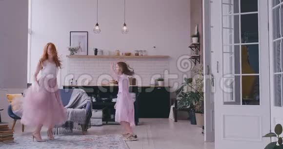 快乐的母亲小女儿站在家里的客厅里一起跳着最喜欢的歌儿童视频的预览图