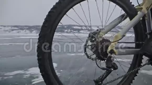 轮胎视图拍摄每秒180帧男人在冰上骑自行车骑自行车的人在镜头前开小差冰块视频的预览图