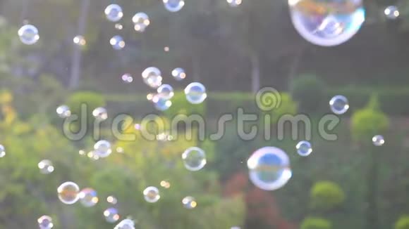 4k肥皂泡漂浮在空气中自然的绿色模糊的背景适合公园里的儿童和儿童视频的预览图