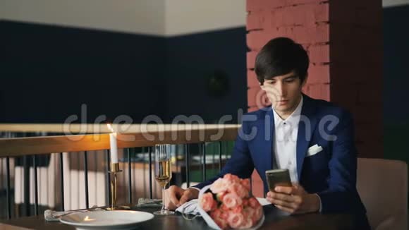穿着得体的愤怒的年轻人正在餐馆等他已故的女朋友用智能手机然后离开现代视频的预览图